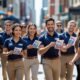 Equipe profissional distribuindo material em calçada movimentada — exemplo de como fazer panfletagem na rua com eficiência
